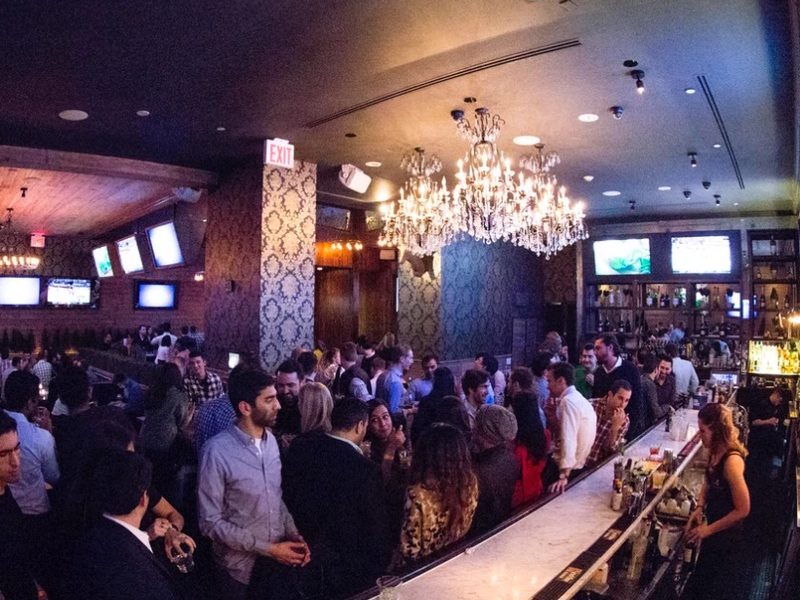 A packed room under the chandeliers